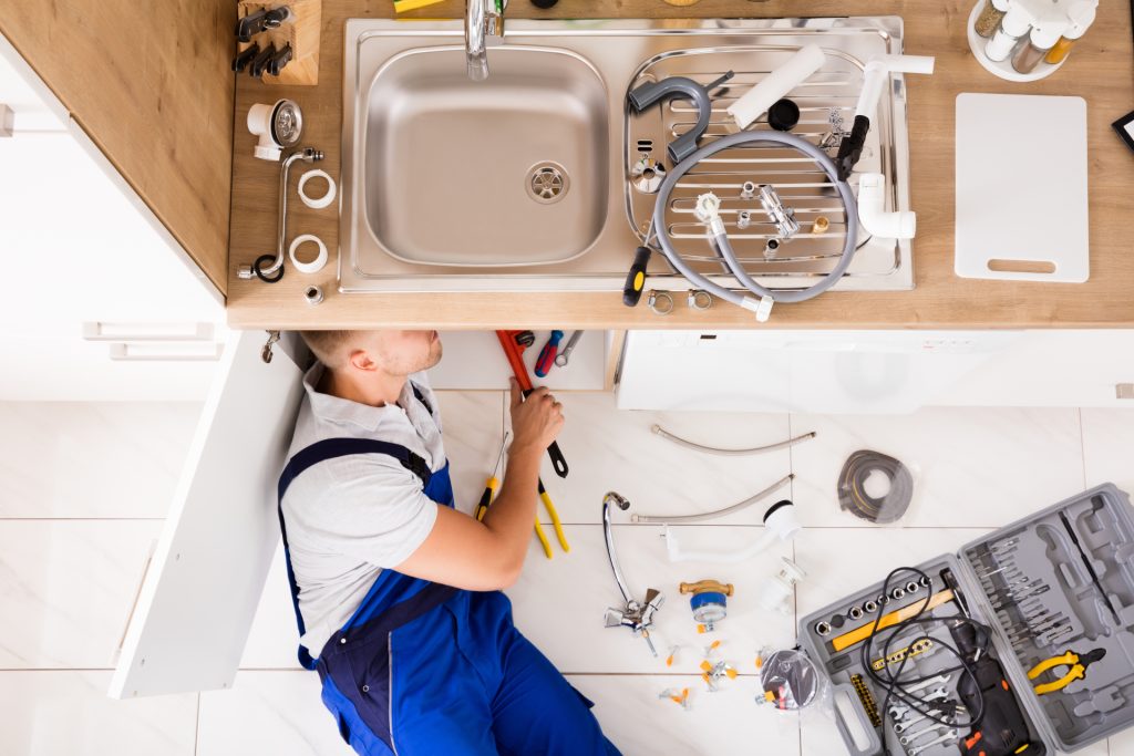 a plumber working on a kitchen sink